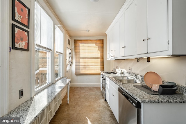 kitchen with stainless steel appliances, a sink, white cabinetry, and baseboards