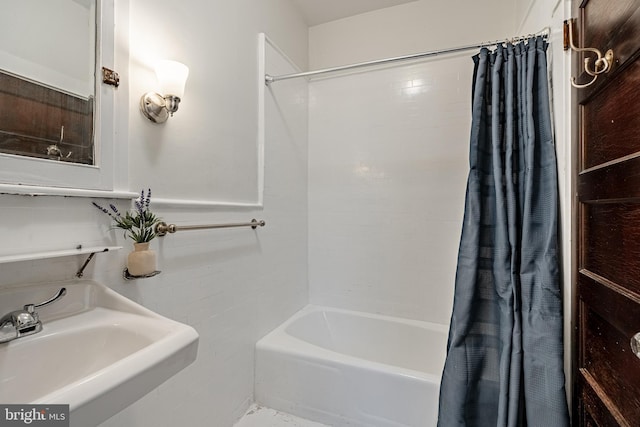 bathroom with shower / bath combo and a sink