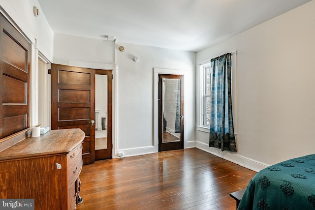 bedroom featuring hardwood / wood-style floors and baseboards