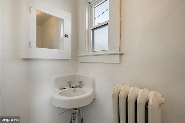 bathroom featuring radiator and a sink