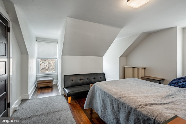 bedroom with lofted ceiling, baseboards, and wood finished floors