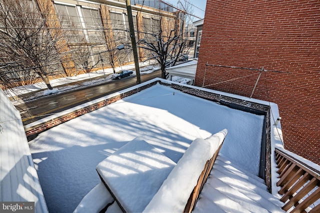 snow covered patio with a balcony