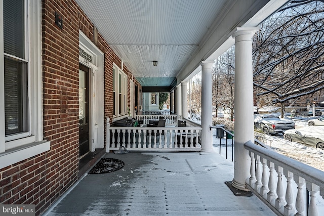 snow covered patio featuring a porch