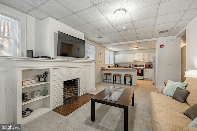 living room featuring a healthy amount of sunlight, visible vents, and a fireplace