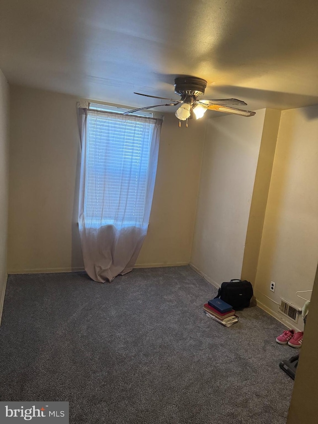 spare room featuring ceiling fan, visible vents, and carpet flooring