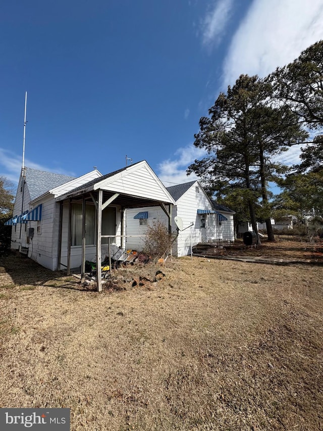 rear view of property with a shingled roof