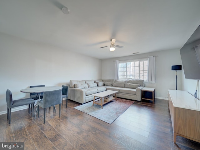 living area featuring visible vents, dark wood finished floors, baseboards, and ceiling fan