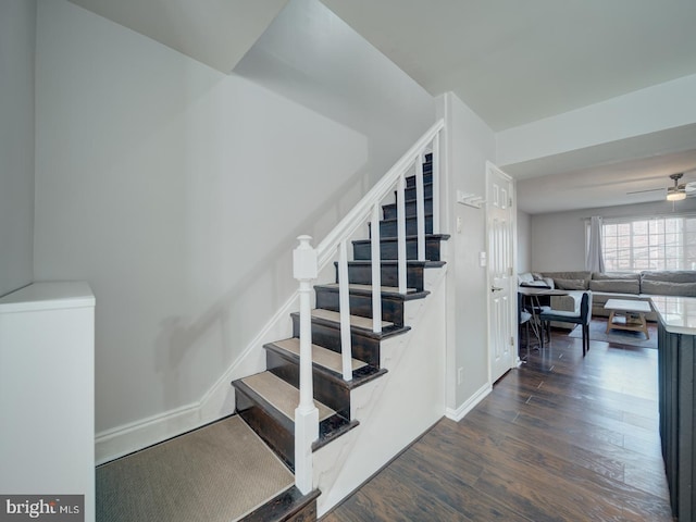 stairway with ceiling fan, baseboards, and wood finished floors