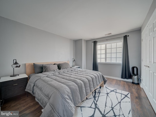 bedroom featuring dark wood-type flooring, visible vents, and baseboards