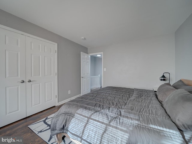 bedroom featuring a closet, baseboards, and wood finished floors