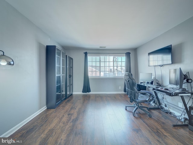 office area with wood finished floors, visible vents, and baseboards