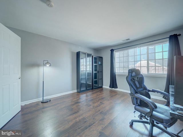 office area with visible vents, baseboards, and wood finished floors