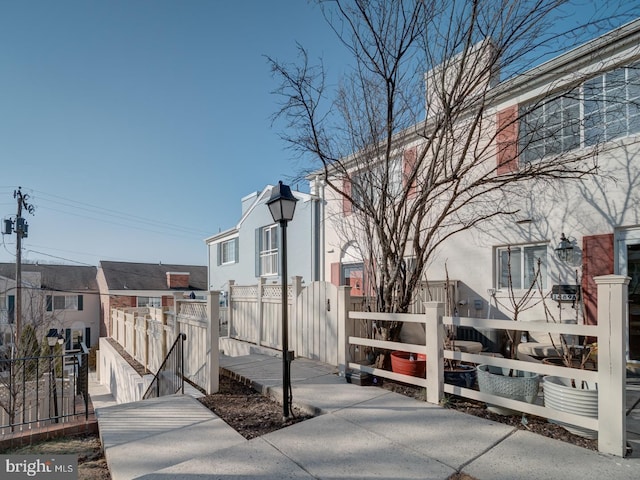 exterior space with a fenced front yard, a residential view, and a gate