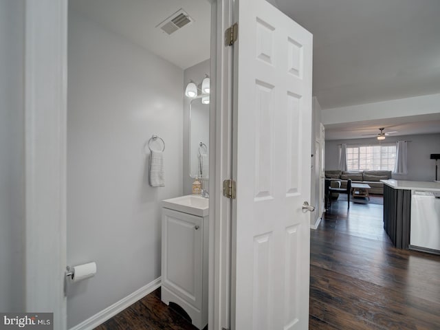 bathroom featuring visible vents, a ceiling fan, vanity, wood finished floors, and baseboards