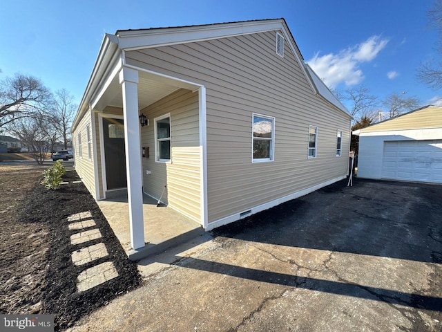 view of property exterior featuring an outbuilding, crawl space, and a detached garage