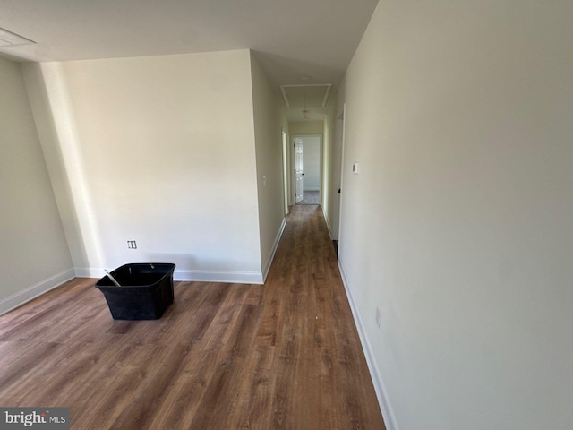 hall with attic access, baseboards, and wood finished floors