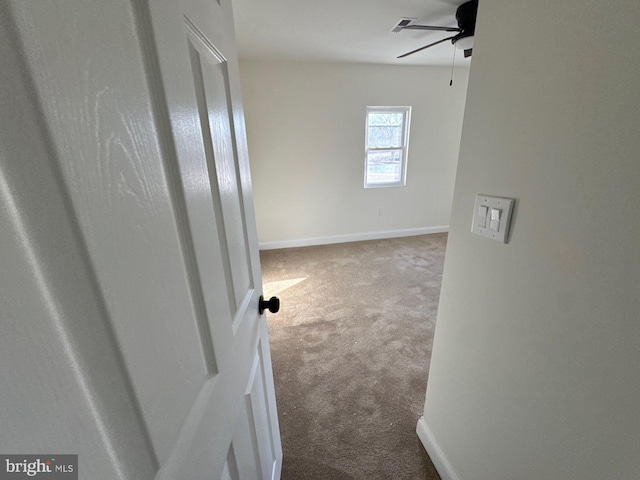 hall featuring carpet flooring and baseboards