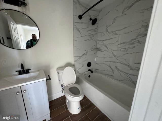 bathroom featuring toilet, wood finish floors, vanity, baseboards, and washtub / shower combination