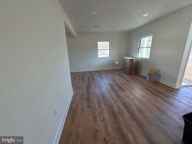 empty room featuring dark wood-style floors and baseboards