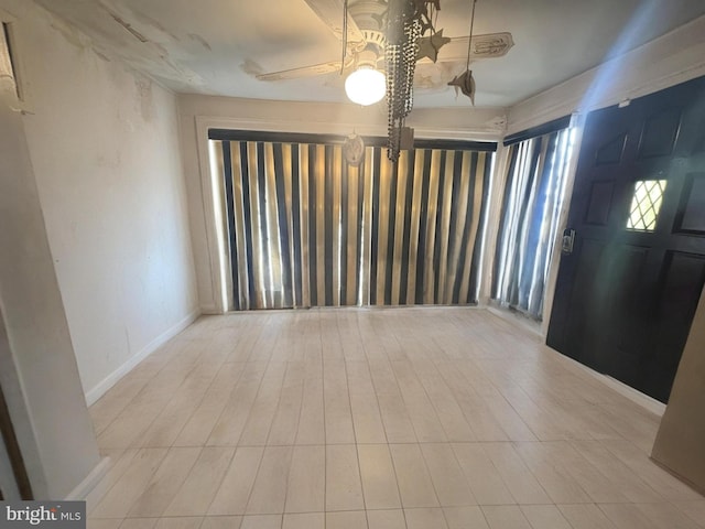 foyer with ceiling fan and baseboards