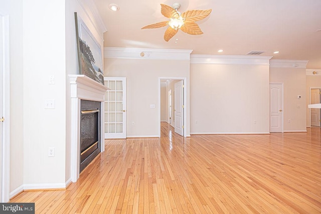 unfurnished living room featuring light wood-type flooring, visible vents, crown molding, and a glass covered fireplace