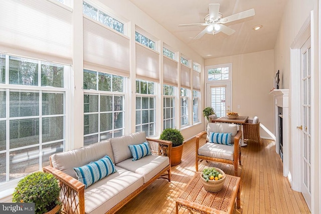 sunroom / solarium featuring a fireplace and ceiling fan