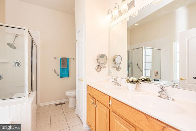 full bathroom with a tile shower, a sink, visible vents, and tile patterned floors