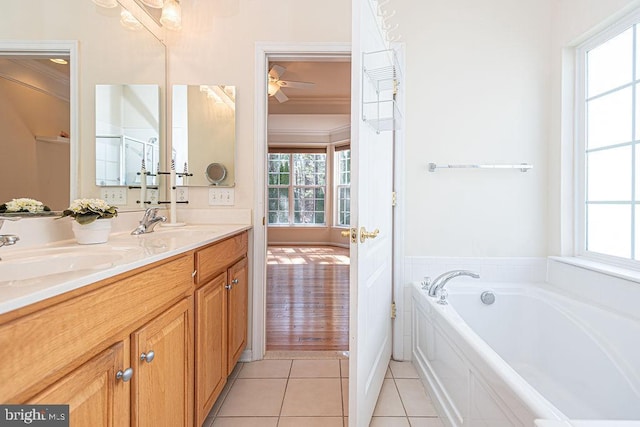 full bath with a sink, double vanity, tile patterned flooring, and a garden tub