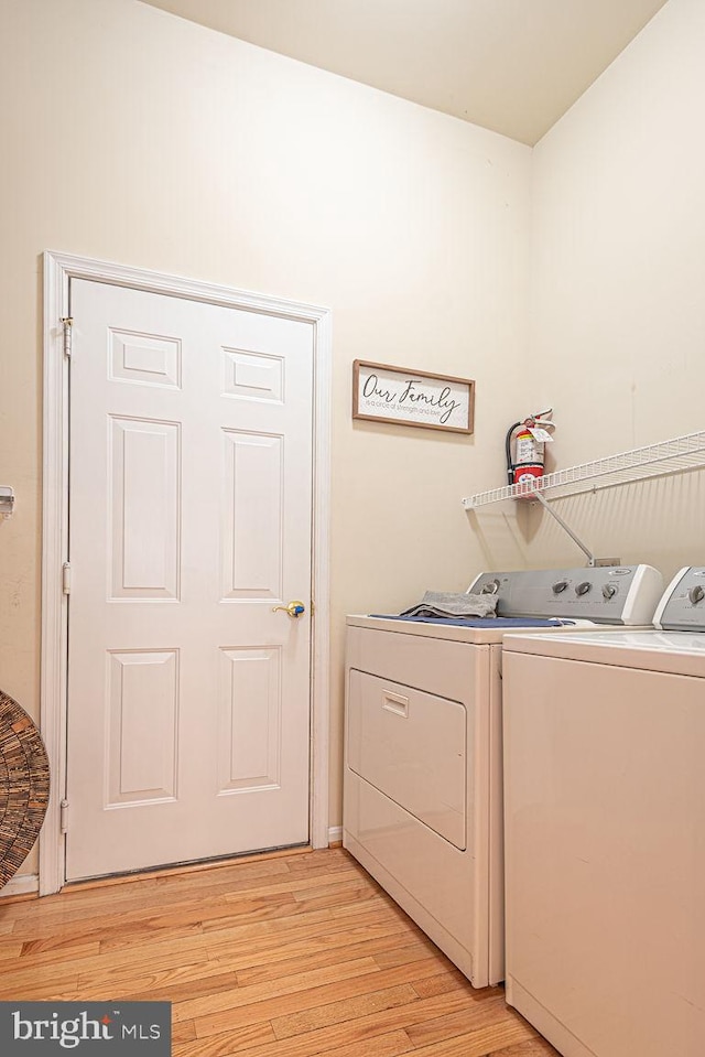 laundry area featuring laundry area, washer and clothes dryer, and light wood finished floors