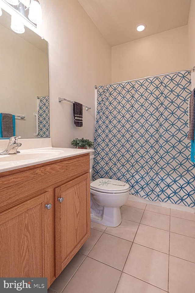 full bathroom featuring toilet, vanity, and tile patterned floors