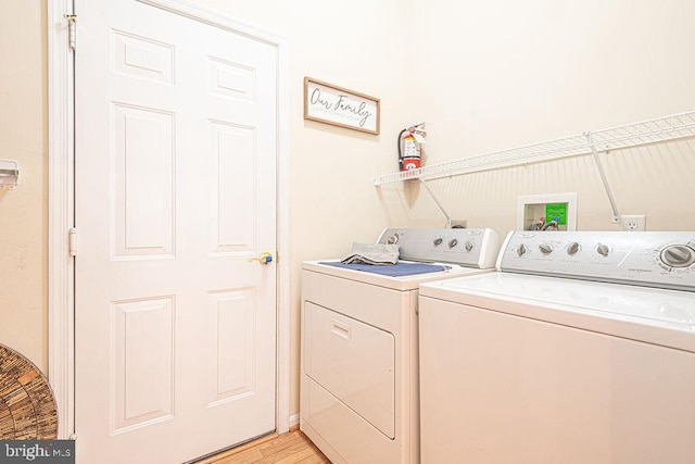 laundry room featuring light wood-type flooring, laundry area, and separate washer and dryer