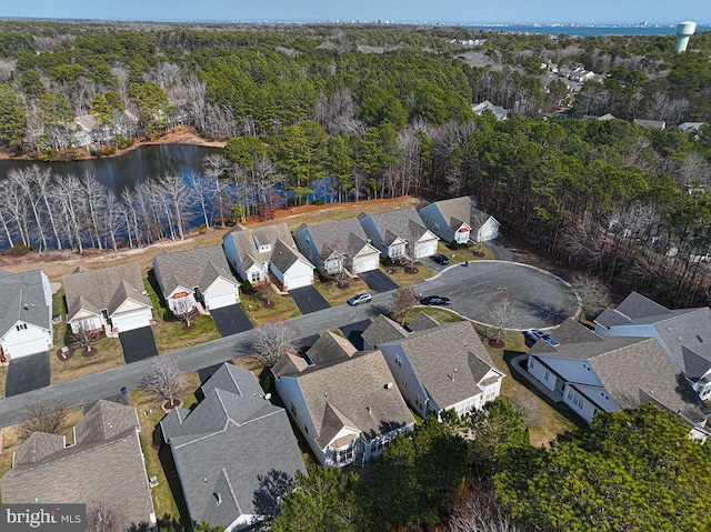 birds eye view of property featuring a water view, a residential view, and a view of trees