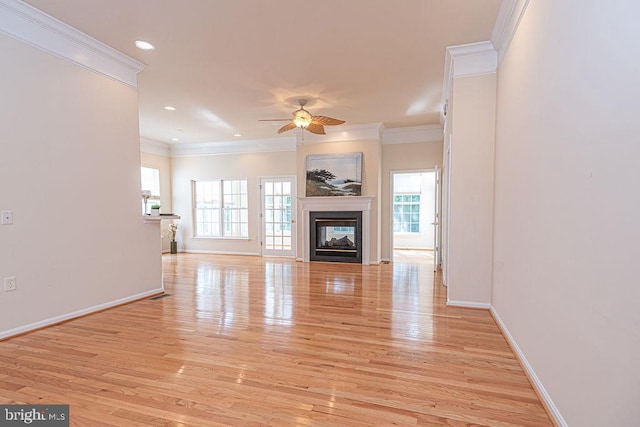 unfurnished living room with light wood-type flooring, baseboards, ceiling fan, and a multi sided fireplace