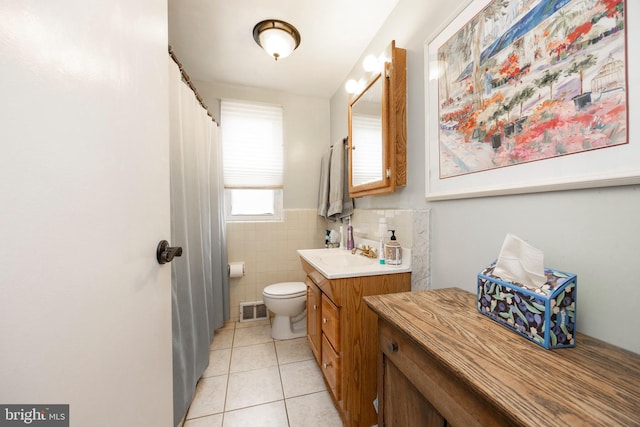 full bathroom featuring visible vents, toilet, tile patterned floors, vanity, and tile walls