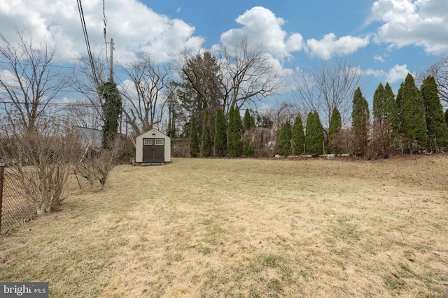 view of yard with a shed, fence, and an outdoor structure