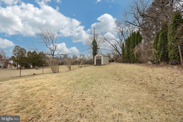 view of yard featuring an outdoor structure, a storage shed, and fence