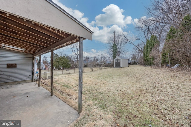 view of yard with a patio area, a shed, and an outbuilding