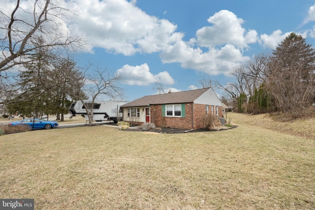 ranch-style home with brick siding and a front yard