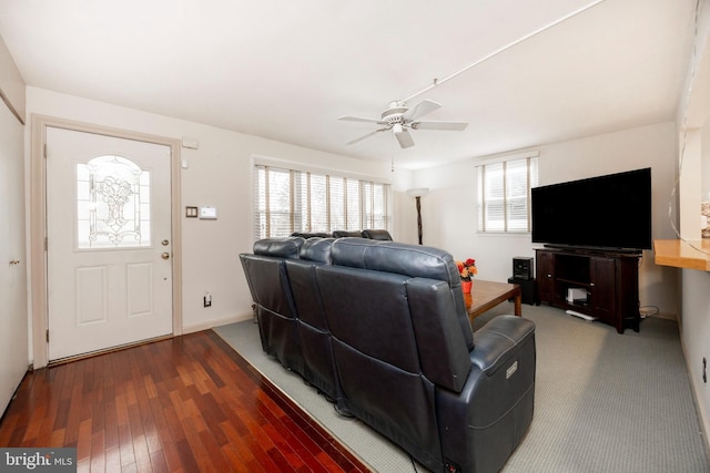 living room featuring ceiling fan, baseboards, wood finished floors, and a healthy amount of sunlight