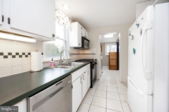 kitchen featuring light tile patterned floors, stainless steel appliances, backsplash, white cabinetry, and a sink