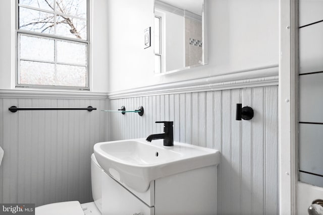 bathroom featuring a wainscoted wall and toilet