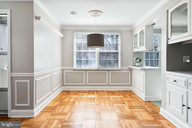 unfurnished dining area featuring ornamental molding and a decorative wall