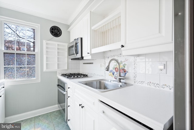 kitchen featuring ornamental molding, a sink, light countertops, appliances with stainless steel finishes, and tasteful backsplash