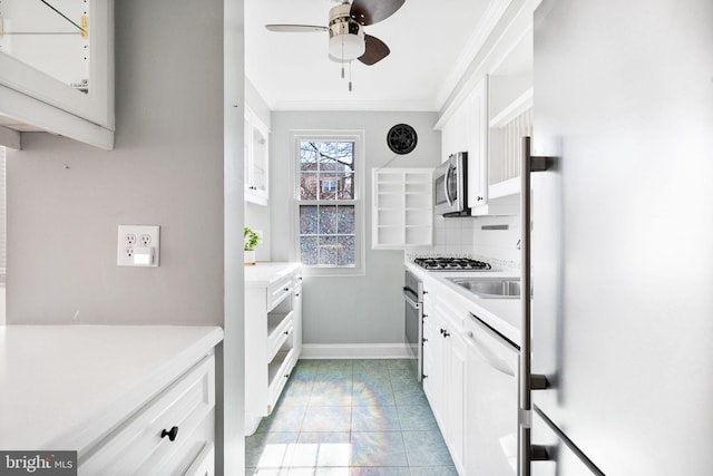 kitchen with ornamental molding, decorative backsplash, light countertops, white cabinets, and appliances with stainless steel finishes