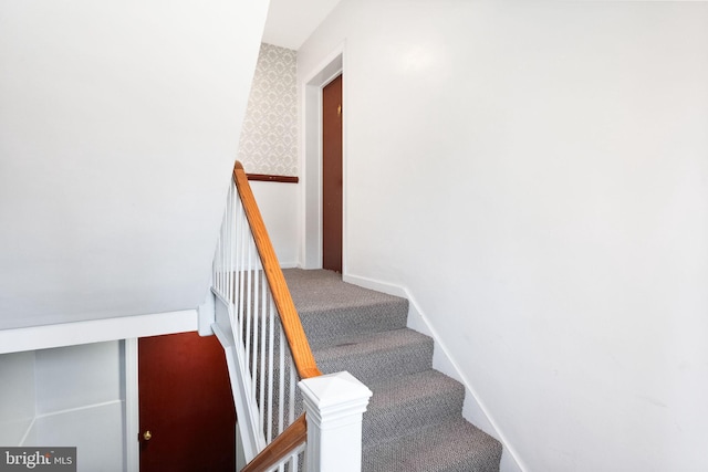 stairway featuring baseboards, carpet, and wallpapered walls