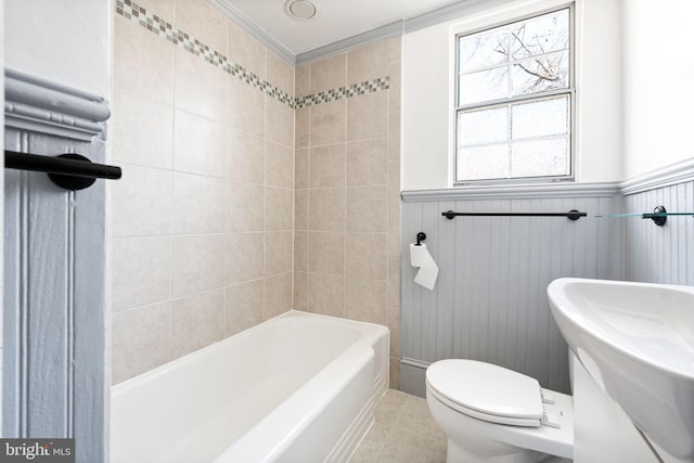 full bathroom with a wainscoted wall, toilet, and tile patterned flooring