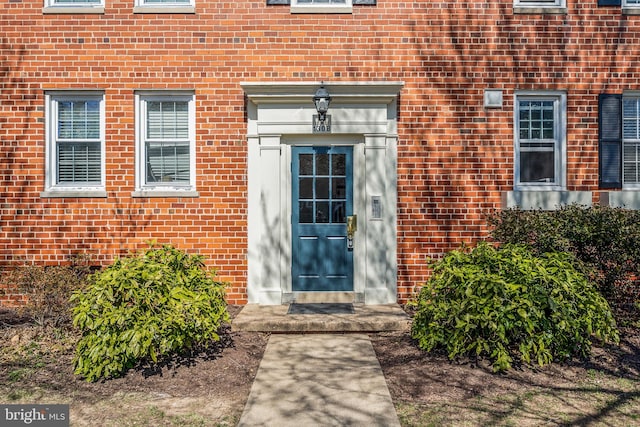 entrance to property featuring brick siding