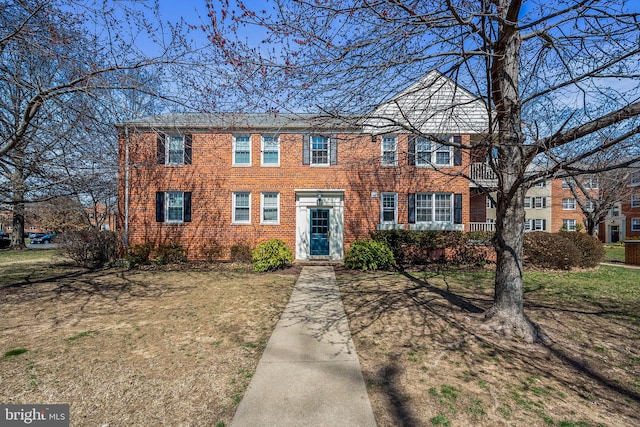 view of front of property featuring brick siding and a front lawn