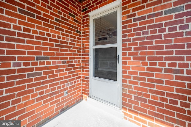 view of exterior entry with brick siding