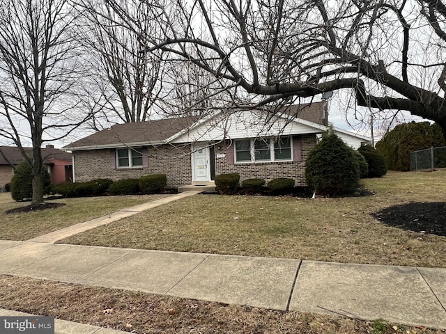 ranch-style home with a front yard and brick siding